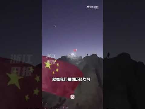 太燃了！男生举着国旗爬山众人为他照光加油