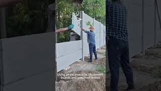 Using excavator to lift cement slabs to build cement fence