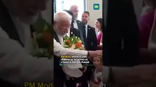 PM Modi interacts with children as he arrives at a hotel in Warsaw, Poland