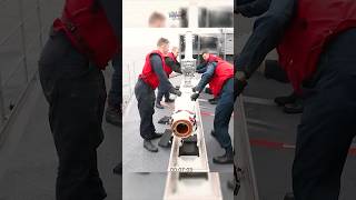 U.S Sailors load a RIM-7P NATO Sea Sparrow missile into its launcher.