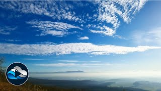 Shapely high clouds over a misty landscape time lapse - Relax in Nature with „Cloud Observe“