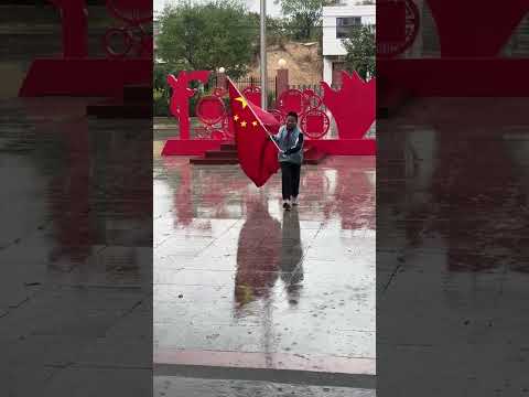 雨中的这一幕让人感动！男孩冲进雨里拾起国旗，为你点赞！
