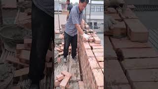 Brick wall laying process at construction site