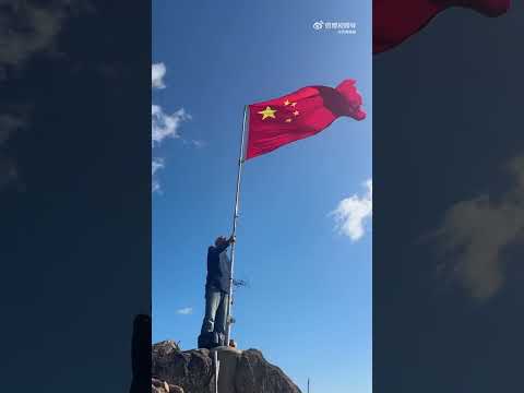 87岁老人爬上山顶升起五星红旗